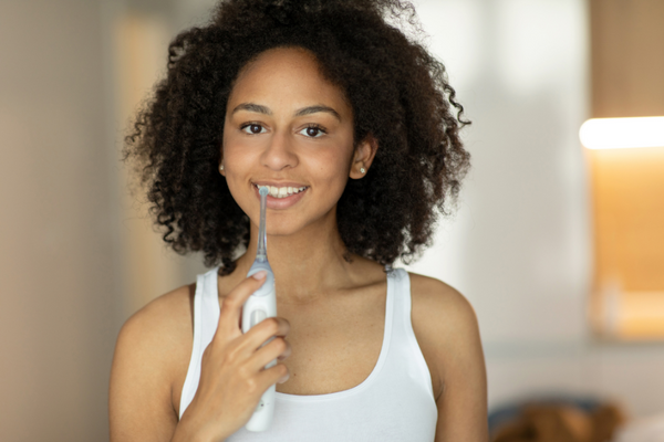 A lady uses a water flosser for the freshest breath.